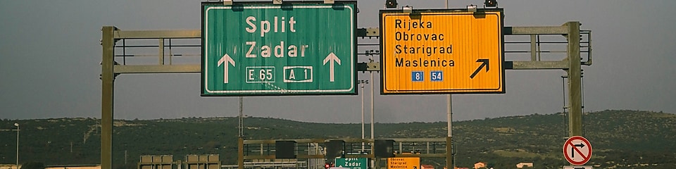 Kamionok és személyautók haladnak a horvát autópályán, az útjelző tábla alatt.