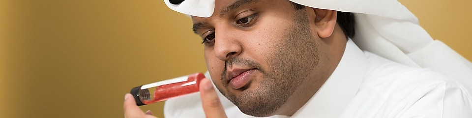 Mohammed Al Athaba egy lezárt kémcső tartalmát vizsgálja