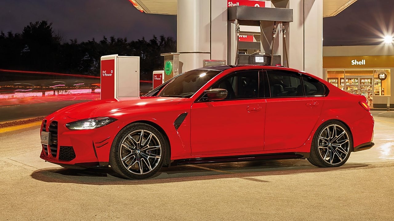 A képen bal oldalán egy mosolygó nőt látunk, a háttérben pedig egy hegyekbe tartó autópályát esti fényekben. A kép közepén pedig a Shell V-Power Diesel logo található.