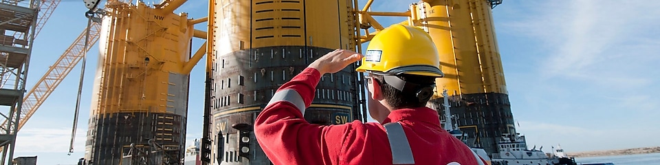 Építés alatti olajfúró platformra felnéző mérnök