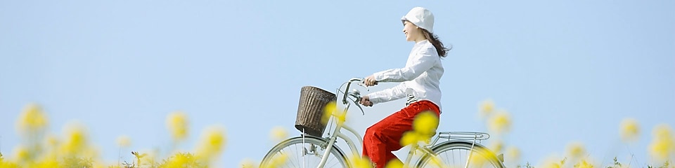 Nyári mezőn bicikliző fiatal nő