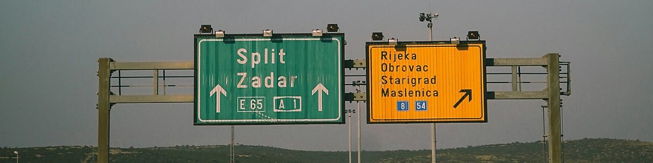 Kamionok és személyautók haladnak a horvát autópályán, az útjelző tábla alatt.