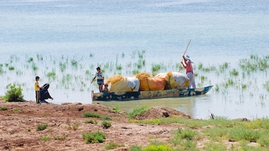 Az elöntött Hawizeh-mocsáron átkelő helyiek, az iraki Majnoon-projekt közelében