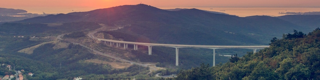 Viadukt, híd szel át dombokat, amelyen egy kamion halad át.