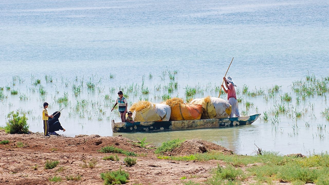 Az elöntött Hawizeh mocsáron átkelő helyiek, az iraki Majnoon-projekt közelében