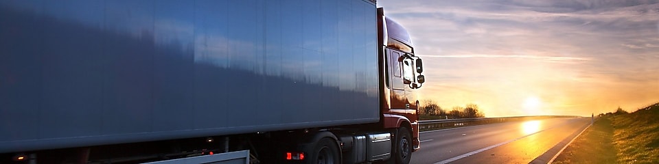 Truck riding towards sunset