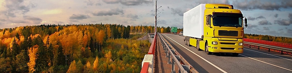 Sárga teherautó a hídon a vidéki területen