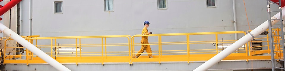 Északi-tengeri olajfúró platformon sétáló mérnök Aberdeenben