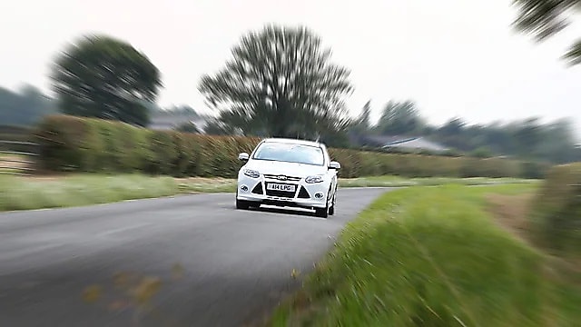 Fehér autó halad egy vidéki úton