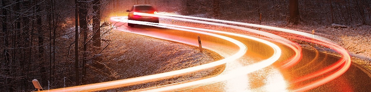 Car on road leaving light trail