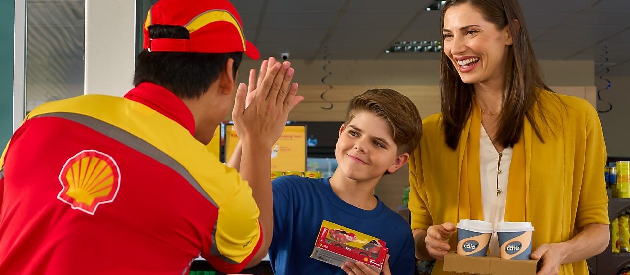 Boldog és elégedett fogyasztók hagyják el a Shell Shopot.