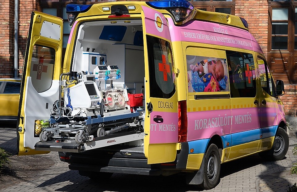 A yellow and pink ambulance with a stretcher