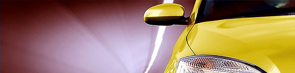 Egy alagútban közlekedő sárga autó elejének, jobb első lámpájának és külső tükrének nézete