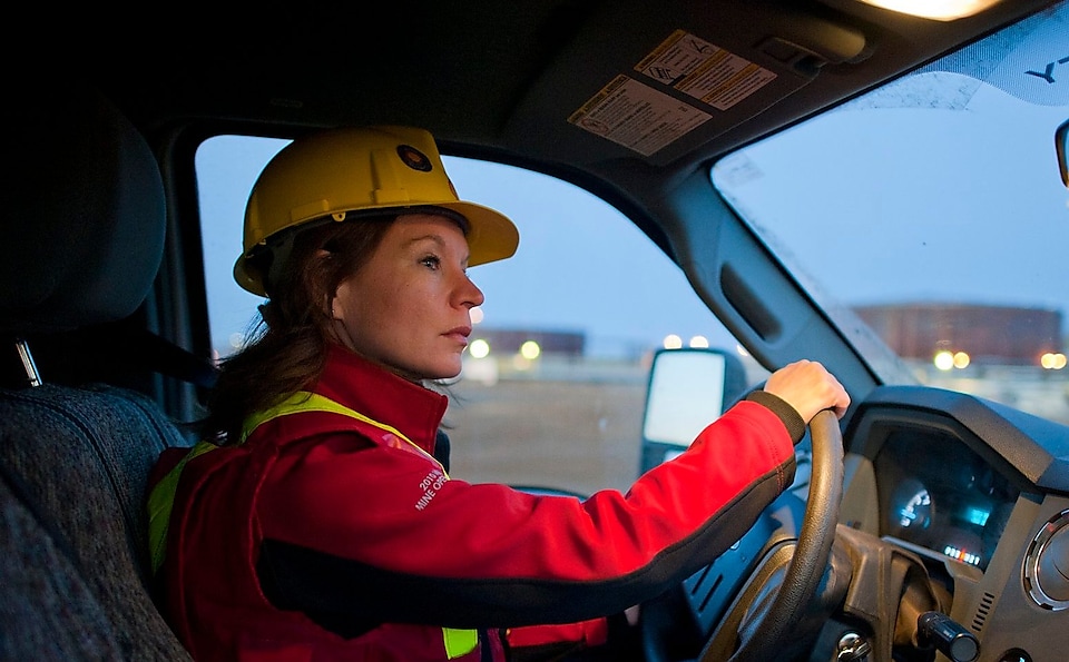 Biztonsági felszerelést viselő, gépjárművet vezető hölgy